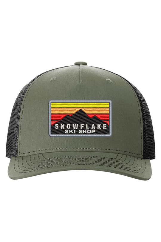 Green cap with a patch featuring 'Snowflake Ski Shop' on a white background