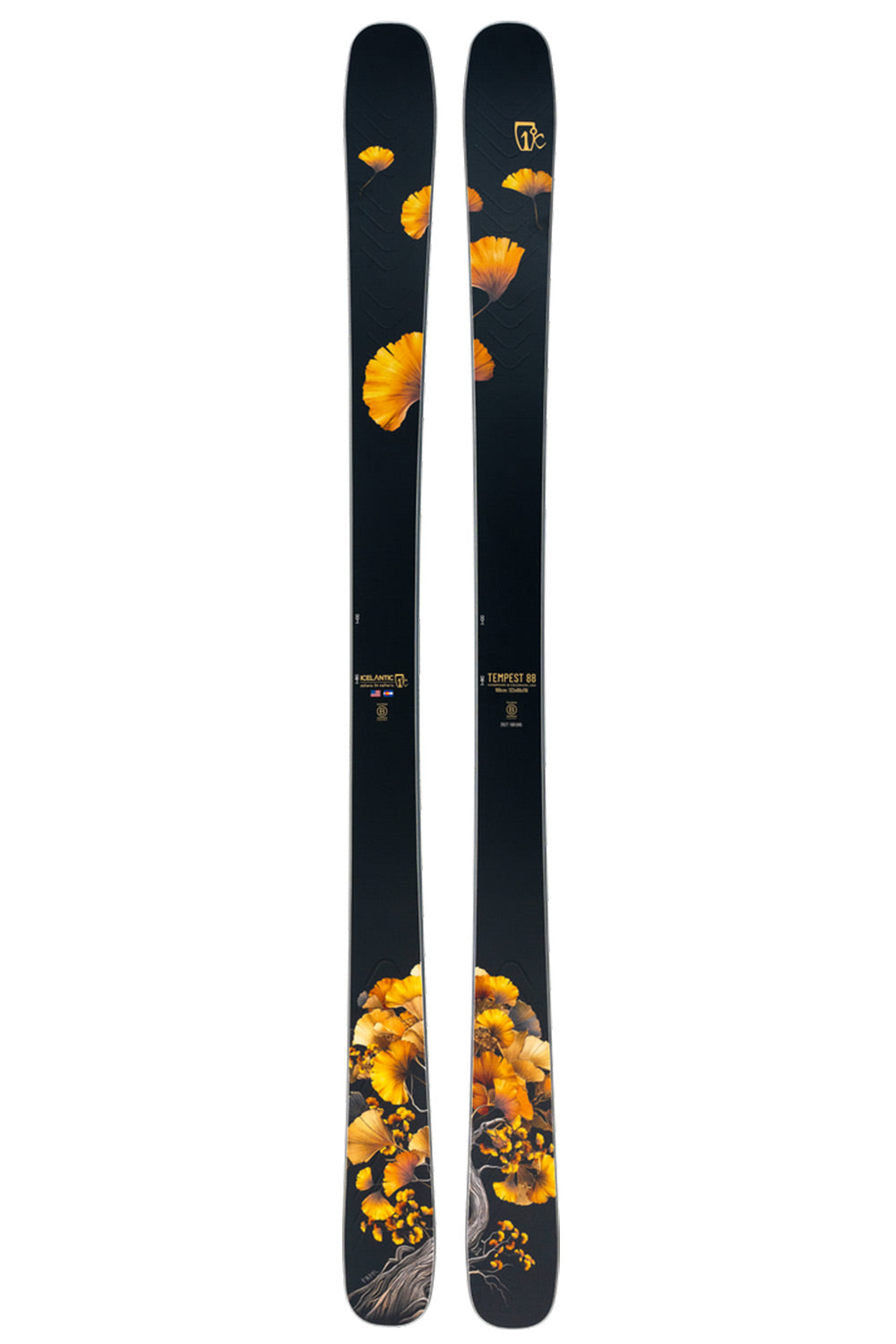 A pair of black skis featuring a vibrant yellow and orange ginkgo leaf pattern, shown vertically against a plain white background.