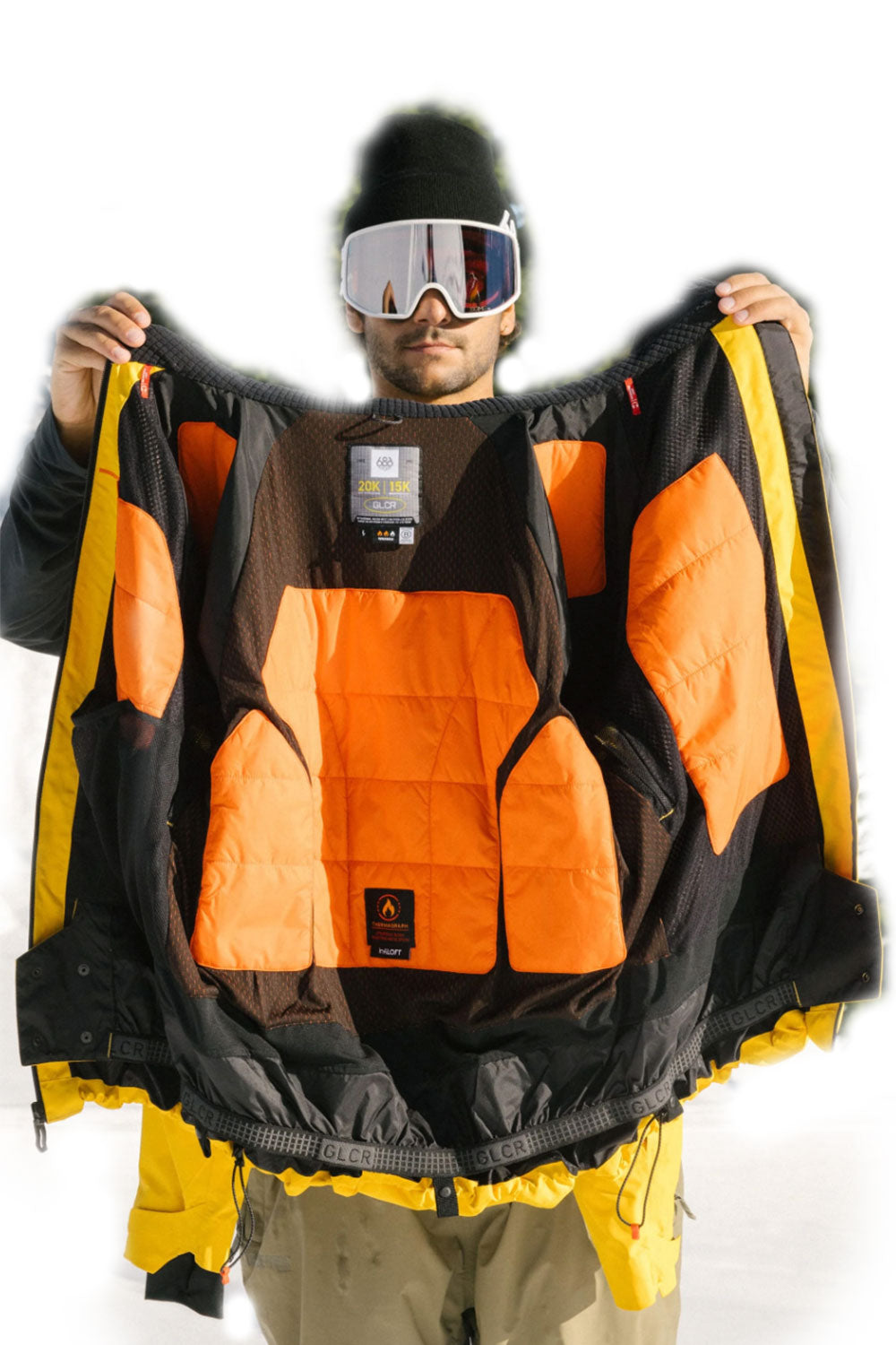 Person wearing an orange and black jacket with yellow accents, holding it open.