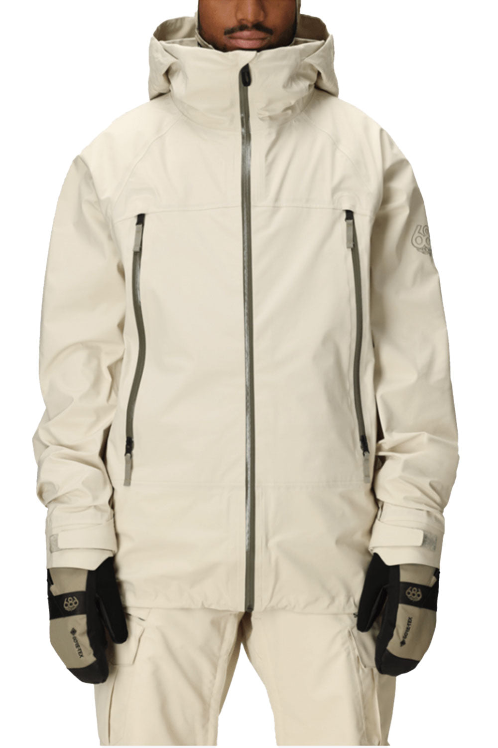Person wearing a beige snow jacket with gloves on a white background