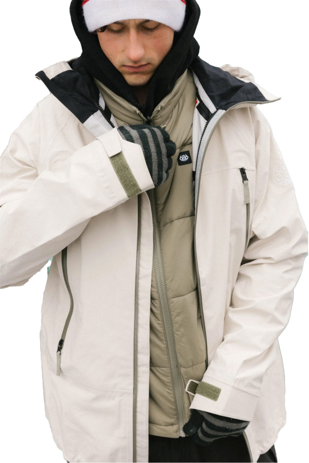 Person wearing a white winter coat with a hood, scarf, and gloves on a white background