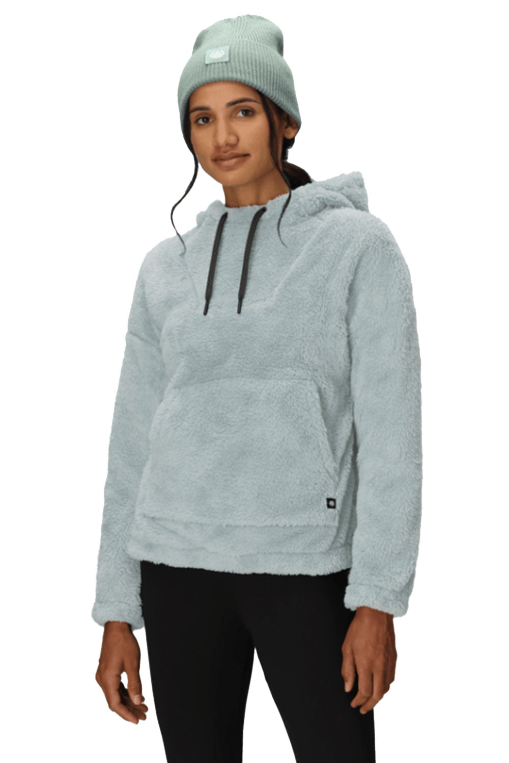 Person wearing a light gray hoodie and a matching beanie on a white background