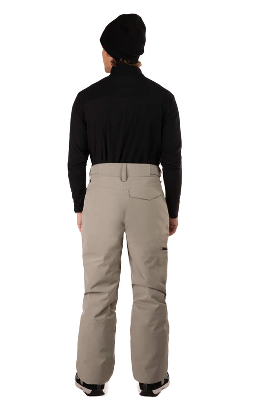 Person wearing a black jacket and beige pants on a white background