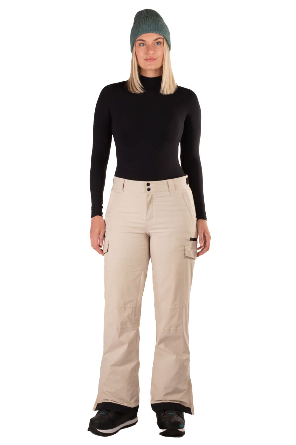 Person wearing a black turtleneck, beige pants, and a green beanie on a white background