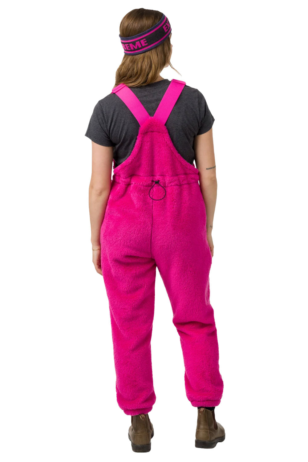 Person wearing pink overalls on a white background