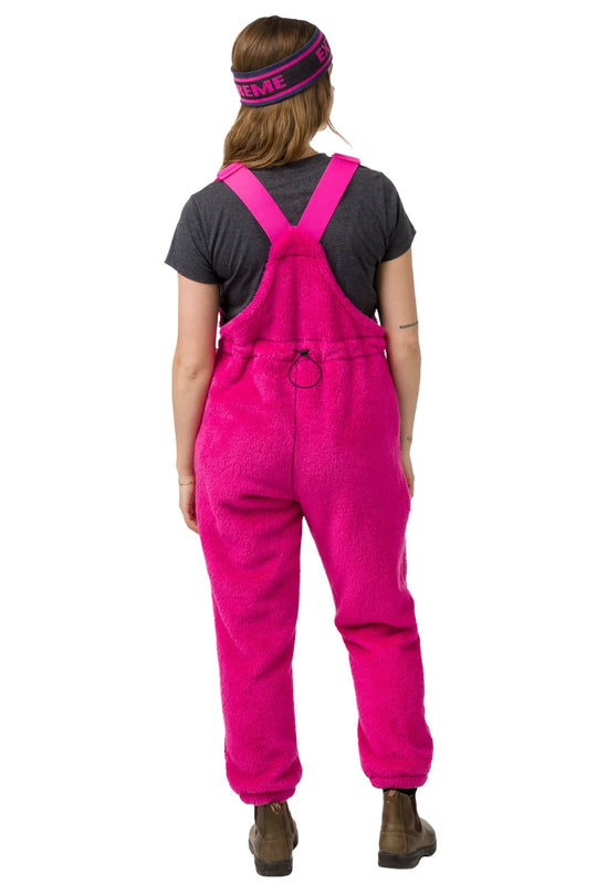 Person wearing pink overalls on a white background