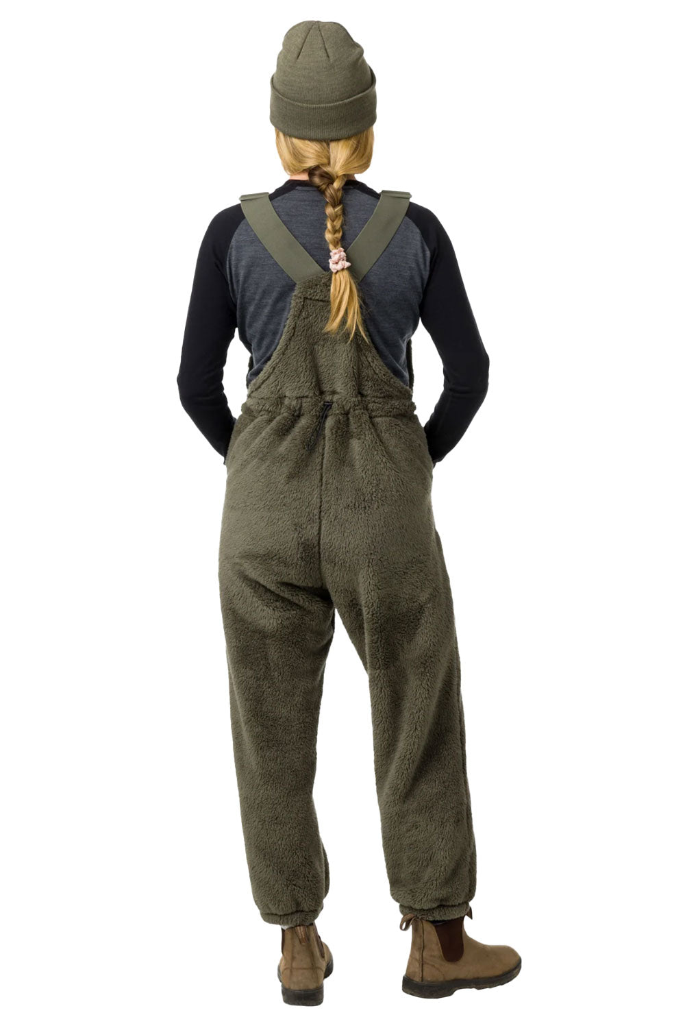 Person wearing green overalls and a beanie on a white background