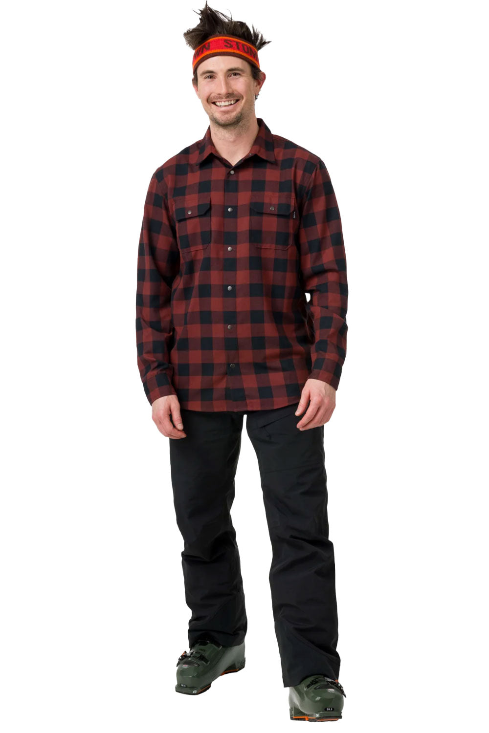 Man wearing a red and black plaid shirt with black pants on a white background