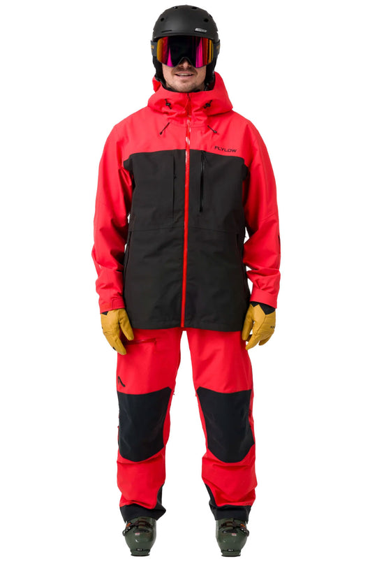 Person wearing a red and black ski jacket with goggles on a white background