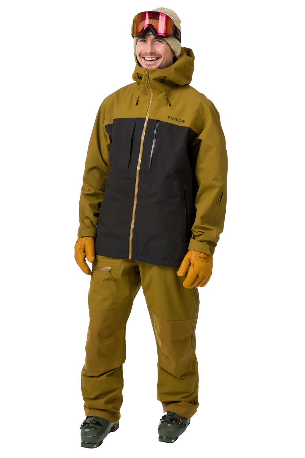 Person wearing a green and black ski jacket with goggles on a white background