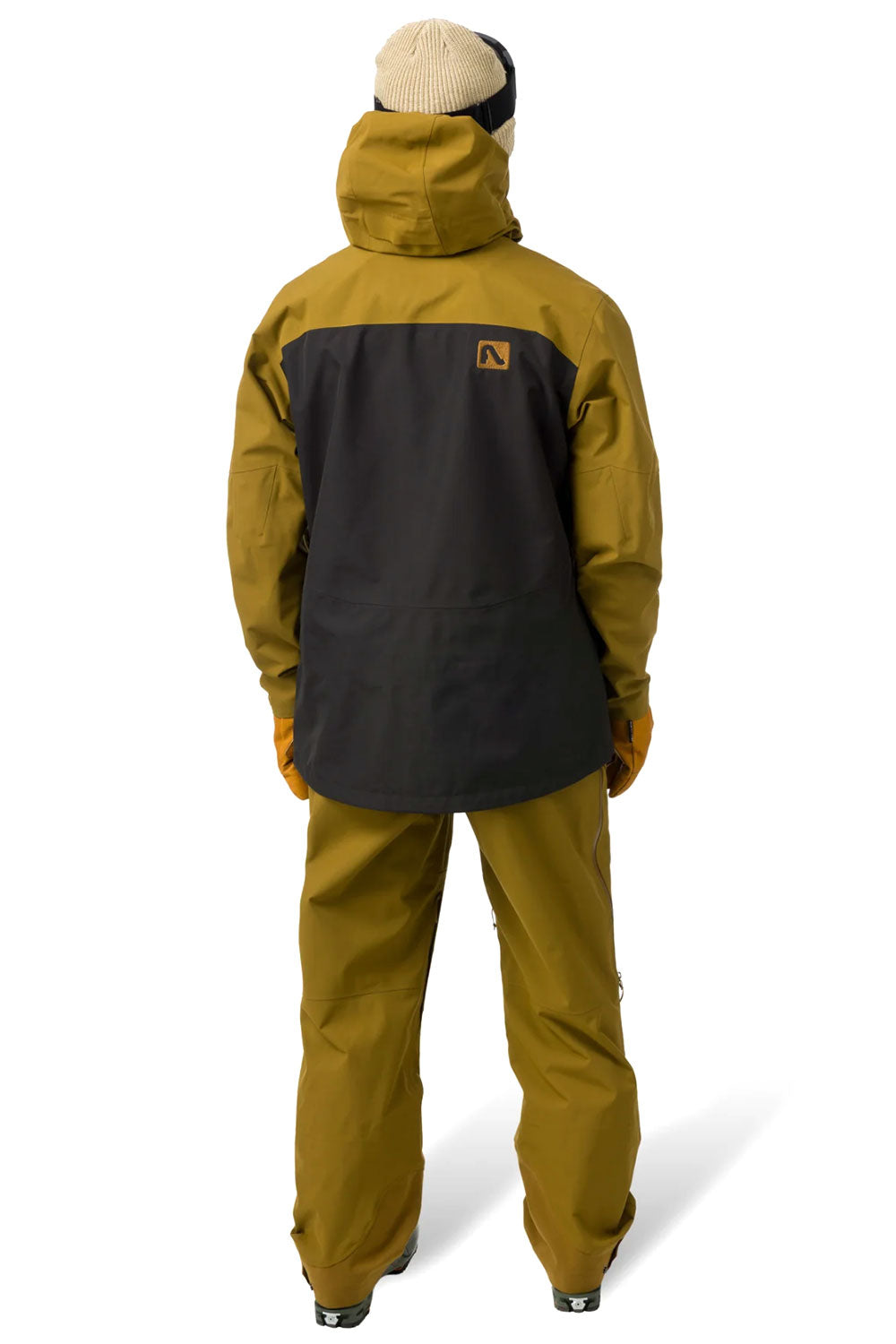 Person wearing a mustard yellow and black ski jacket on a white background
