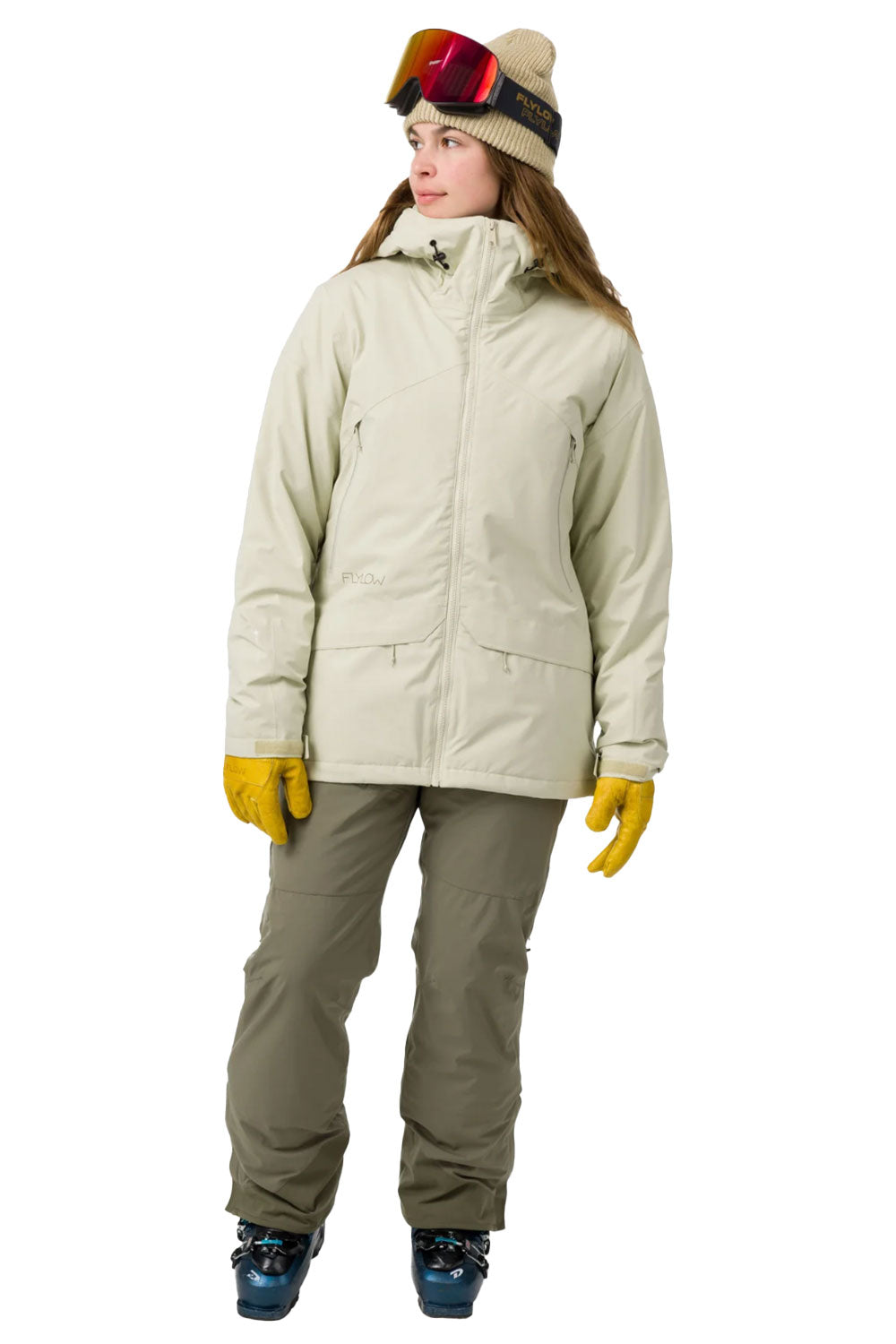 Person wearing a light green snow jacket, pants, and goggles on a white background