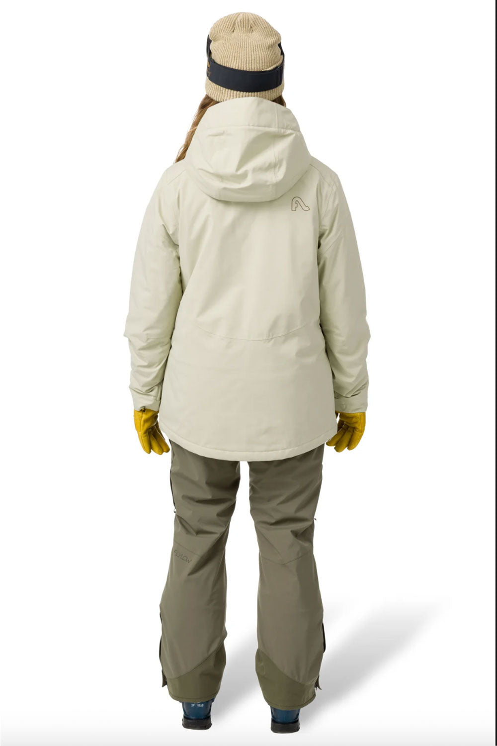 Person wearing a light green winter jacket and pants on a white background