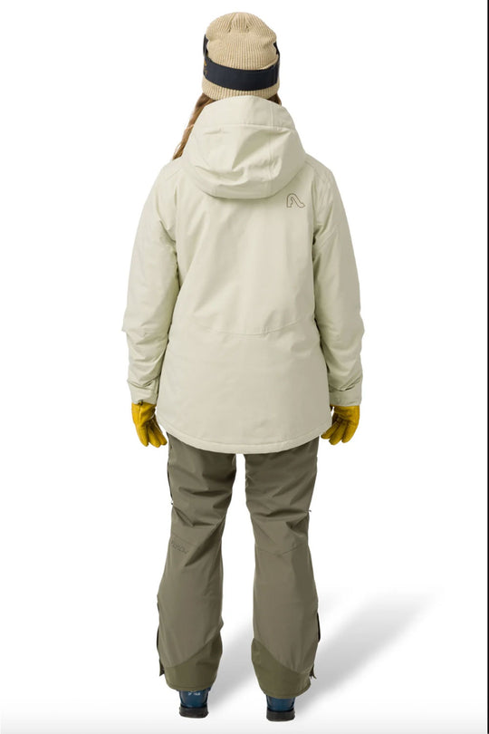 Person wearing a light green winter jacket and pants on a white background