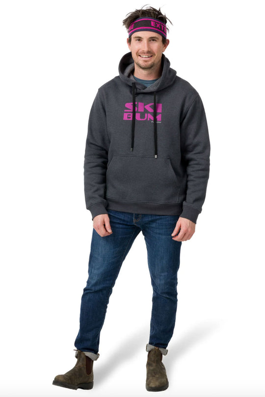 Man wearing a dark gray hoodie with pink text, blue jeans, and brown boots on a white background