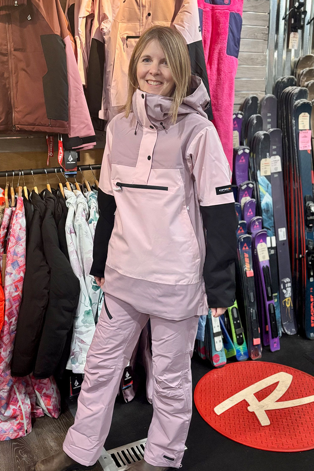 person wearing a pink colorblock ski jacket and pink ski pants