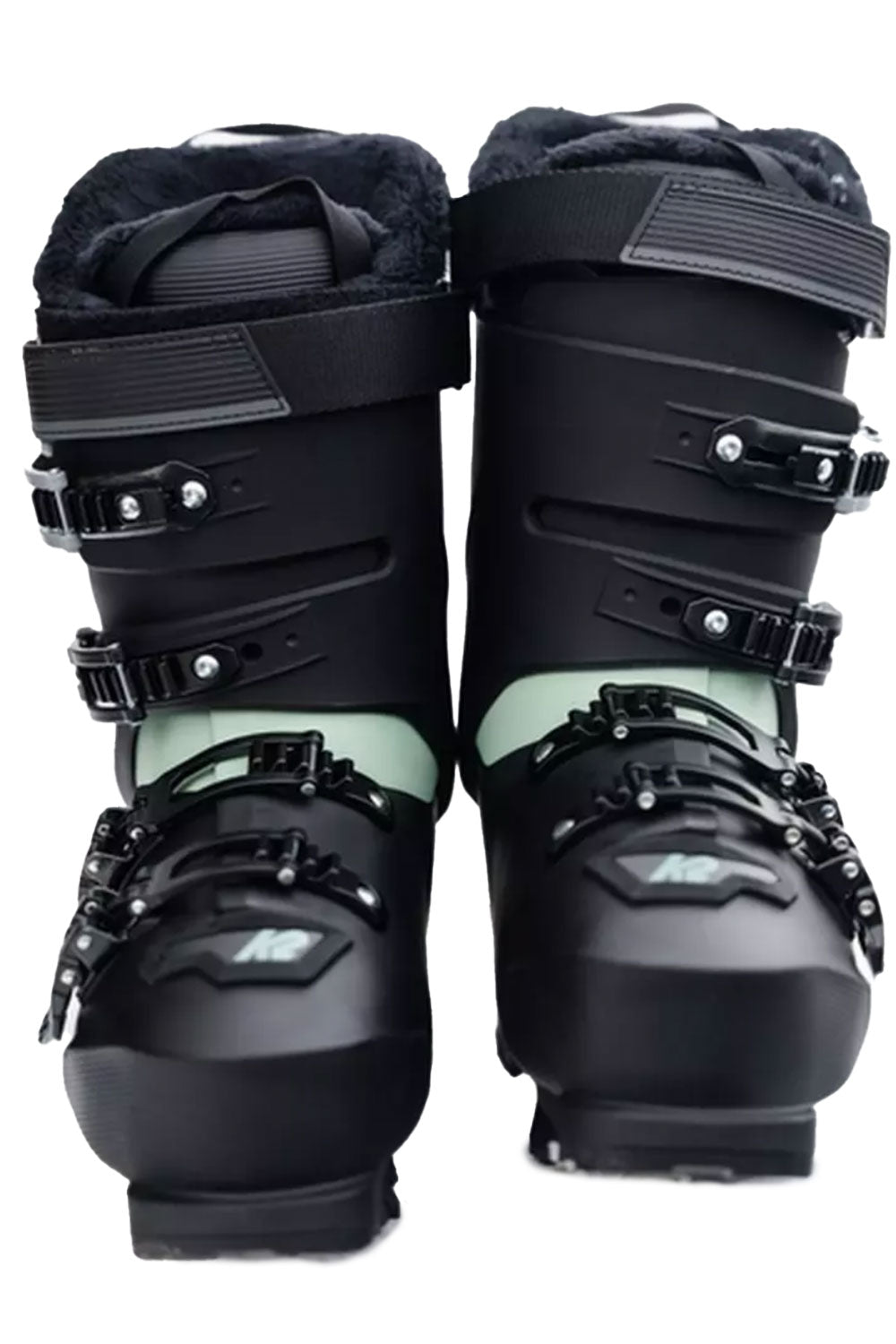Pair of black ski boots with green accents on a white background