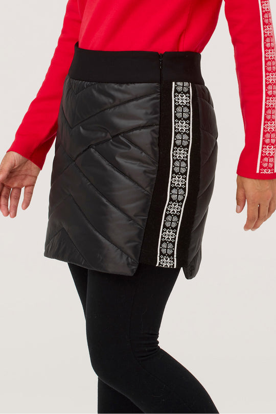 Black puffer skirt with white patterned side panels worn by a person in a red long-sleeve shirt.