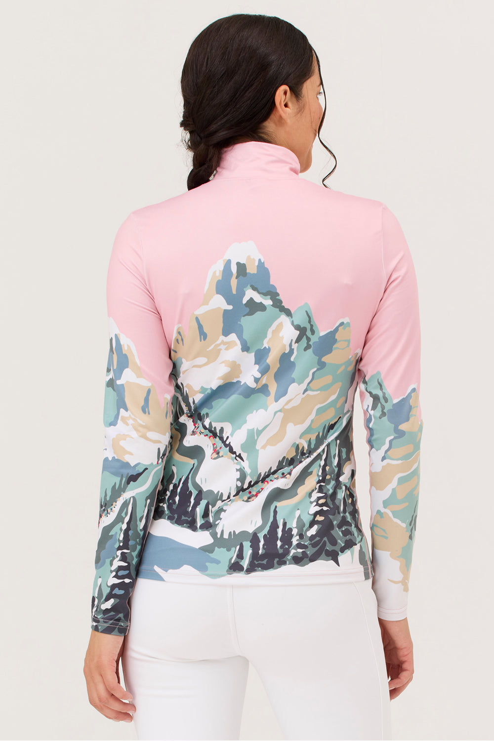 Person wearing a pink and multicolored long-sleeve shirt with a mountain design on a light gray background