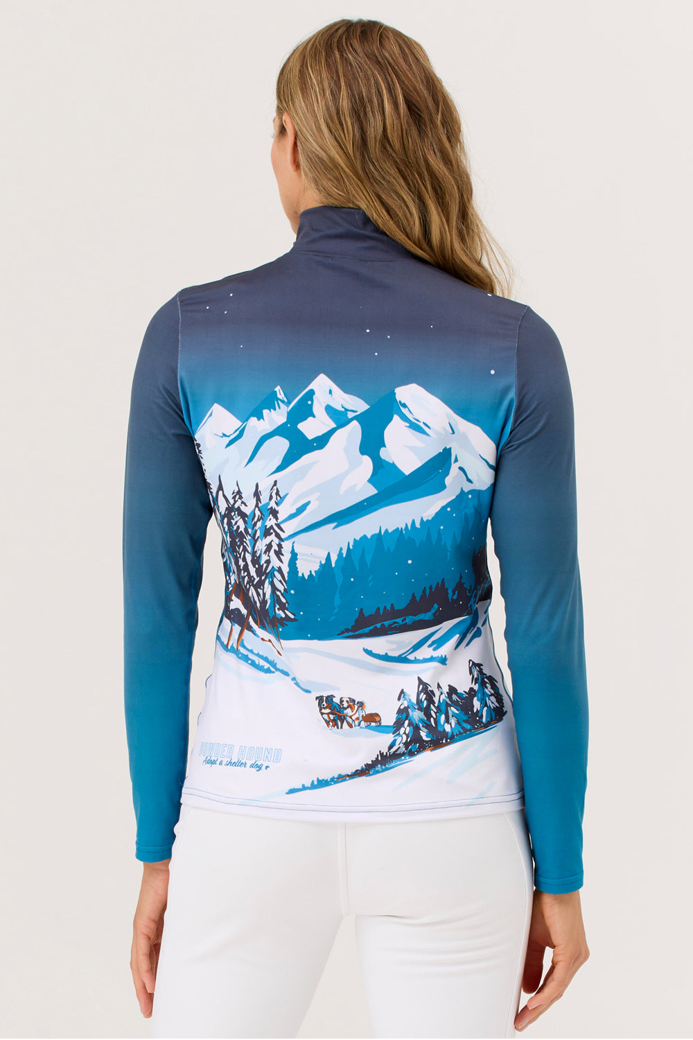 Woman wearing a blue and white long-sleeve shirt with a mountain design on a plain background