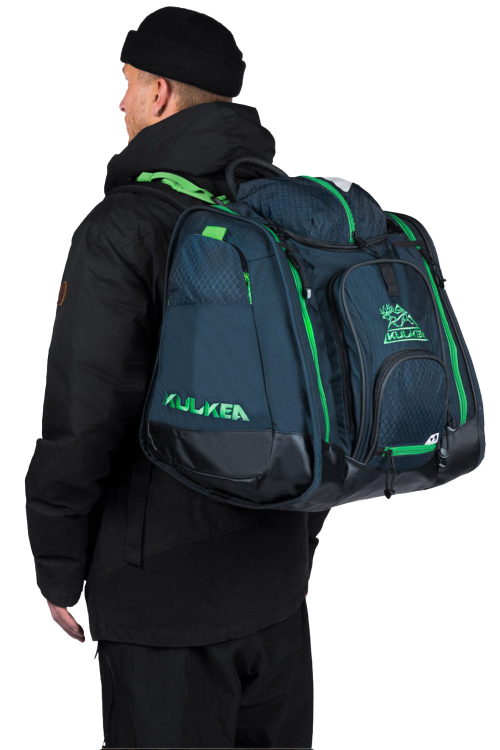 Person wearing a large green and black ski boot backpack with visible branding on a white background