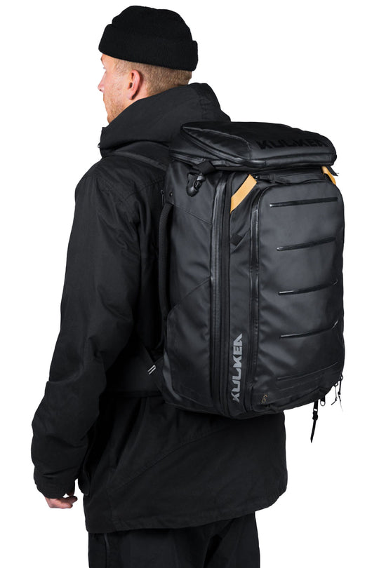person wearing a black ski boot backpack
