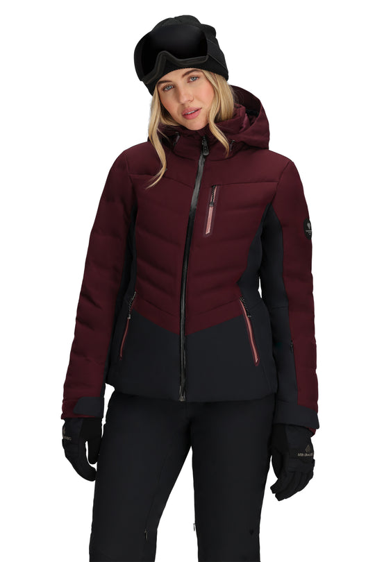 Person wearing a maroon and black ski jacket with goggles on a white background