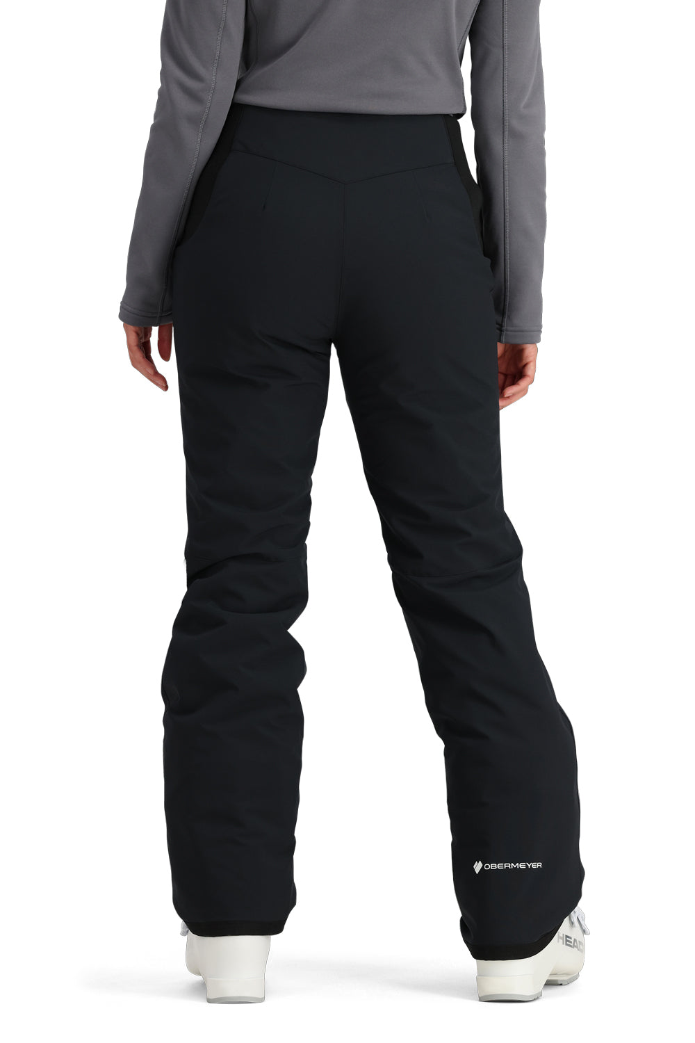 Person wearing black ski pants with a gray top on a white background