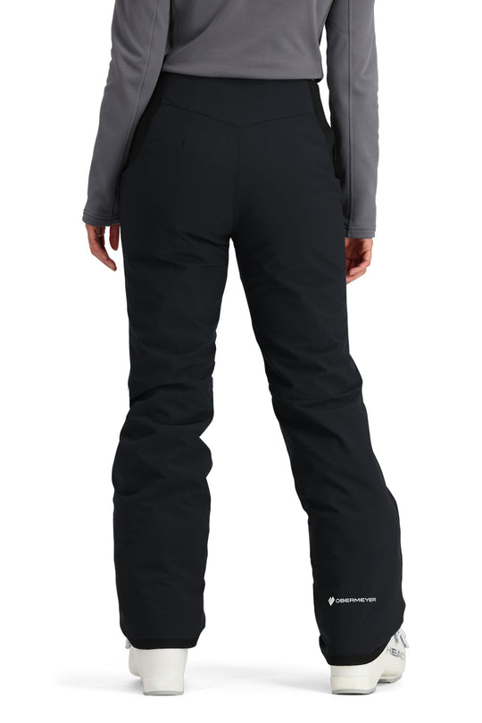 Person wearing black snow pants with a gray top on a white background