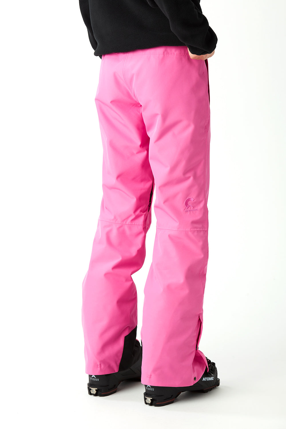 Person wearing bright pink snow pants on a white background