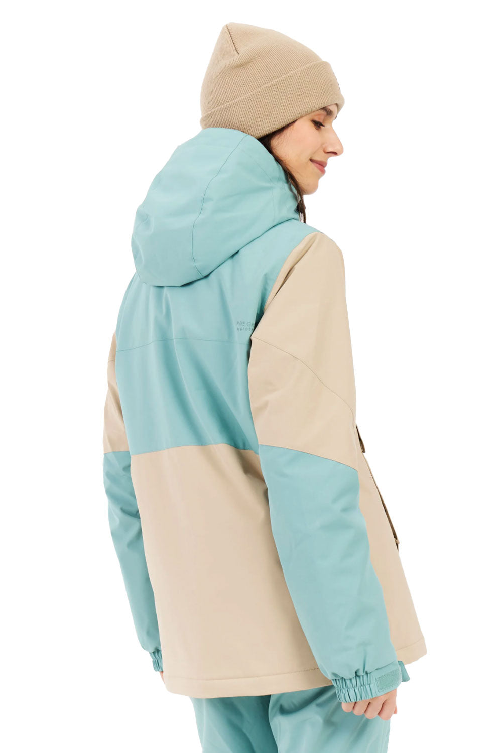 Person wearing a light blue and beige jacket with a beanie on a white background