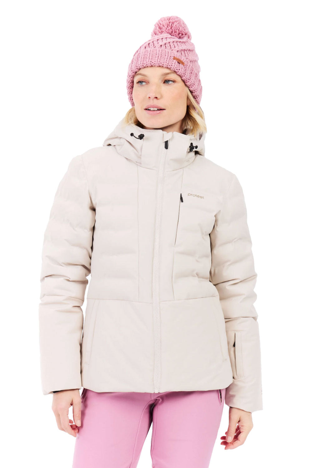 Woman wearing a beige winter jacket and pink pants with a pink beanie on a white background