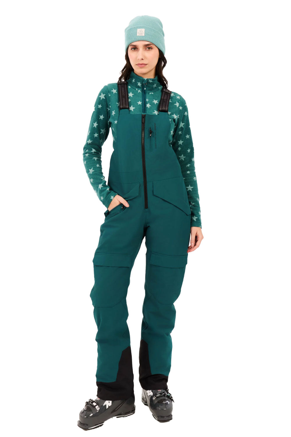 Person wearing a green snowsuit with star pattern on a white background