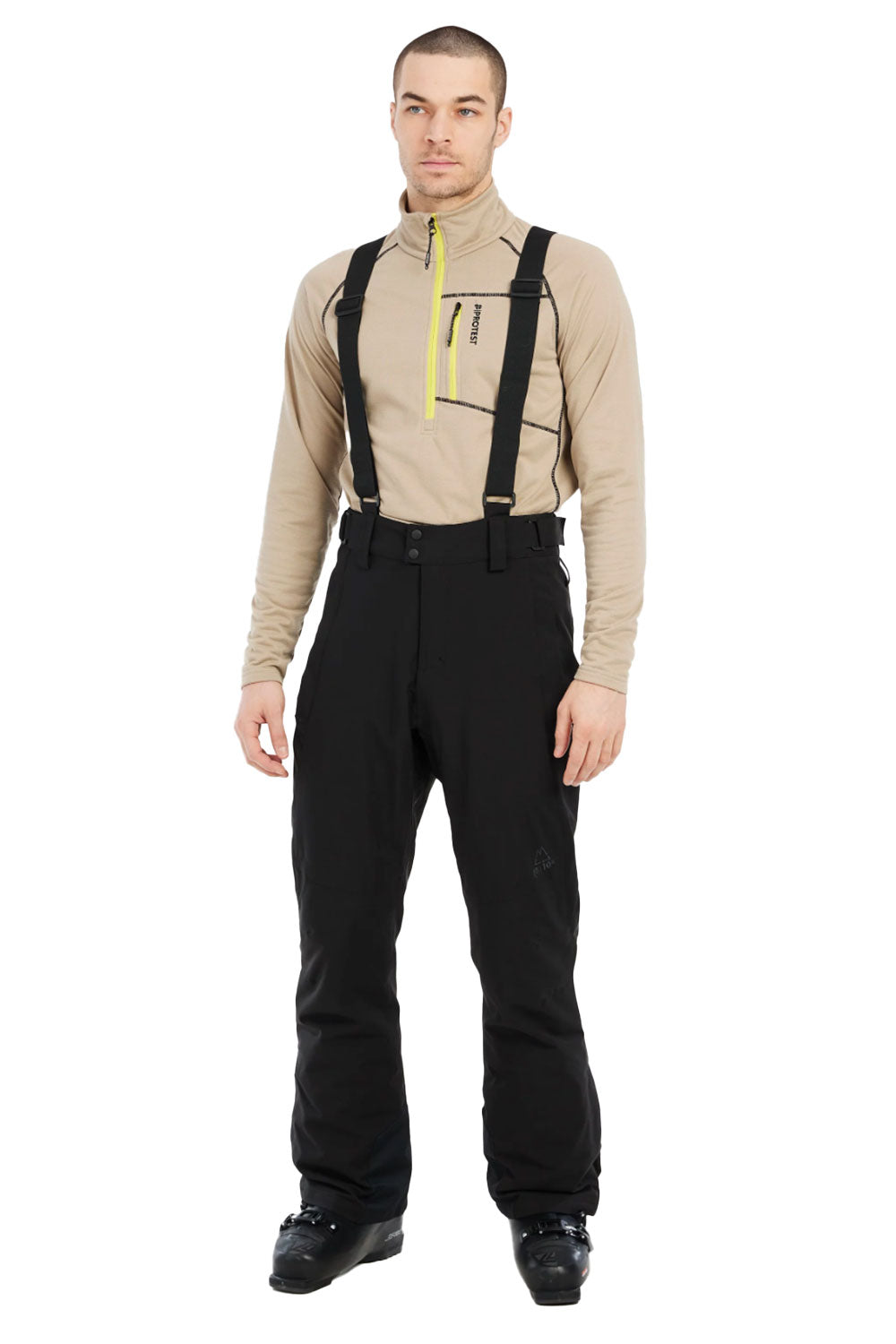 Man wearing a beige shirt, black pants, and suspenders on a white background