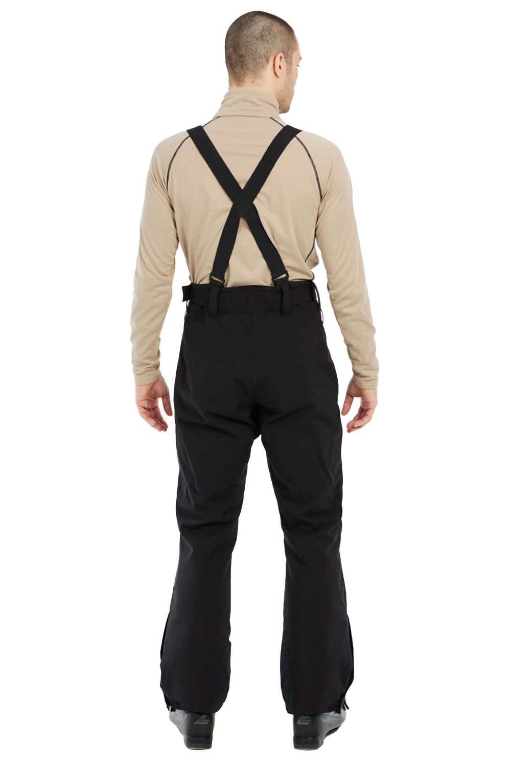 Person wearing black pants with suspenders and a beige shirt on a white background