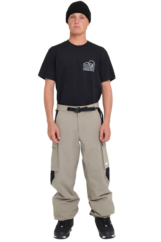 Person wearing a black t-shirt with a logo and beige pants on a white background