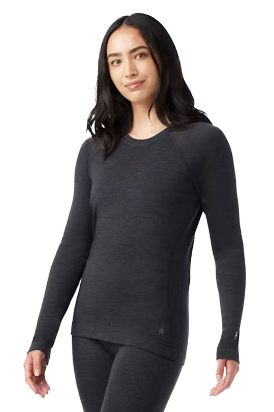 Woman wearing a dark gray long-sleeve top on a white background