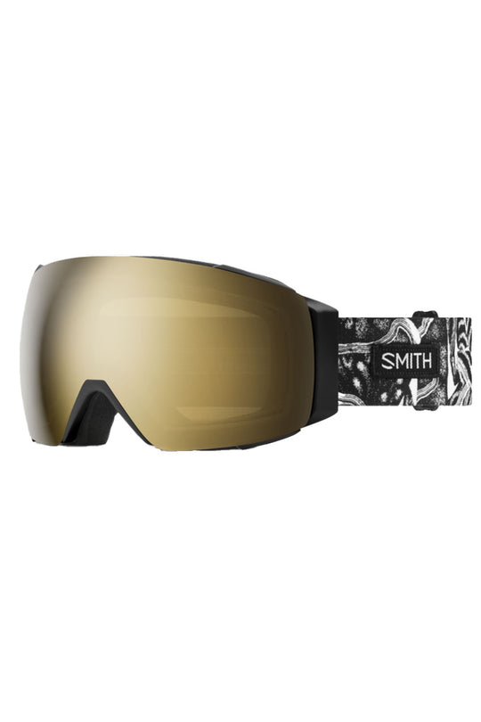 Gold ski goggles with a black and white patterned strap on a white background