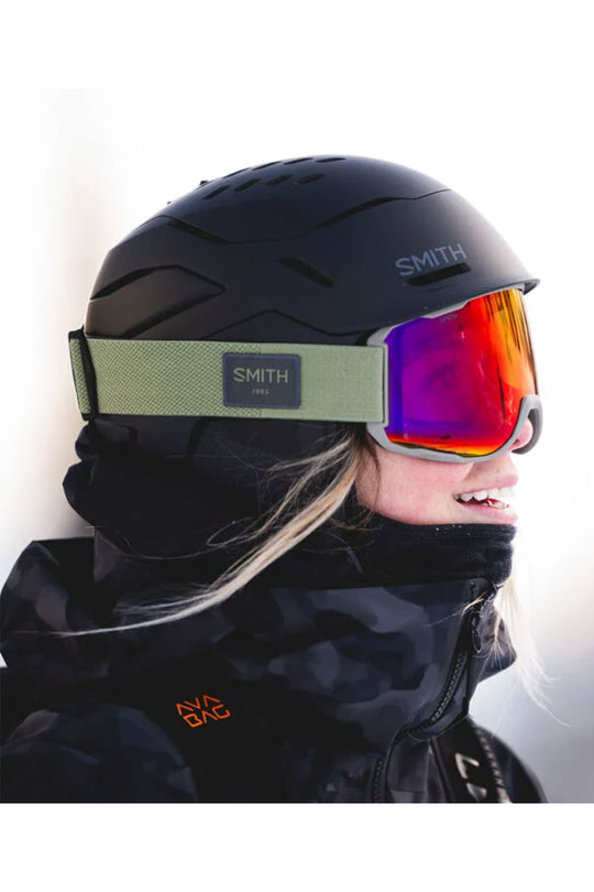 Person wearing a black helmet and goggles with 'Smith' branding on a white background