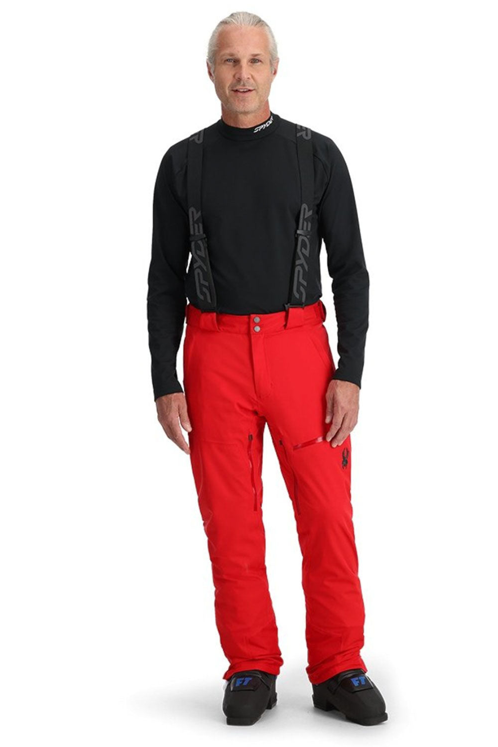 Man wearing black top and red  ski pants on a white background