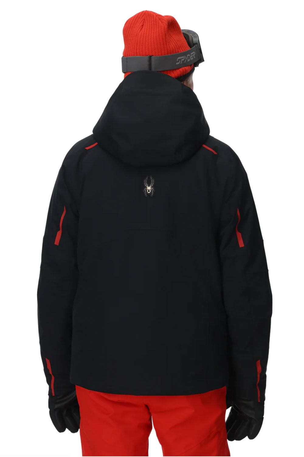 Person wearing a black jacket with red accents and red pants on a white background