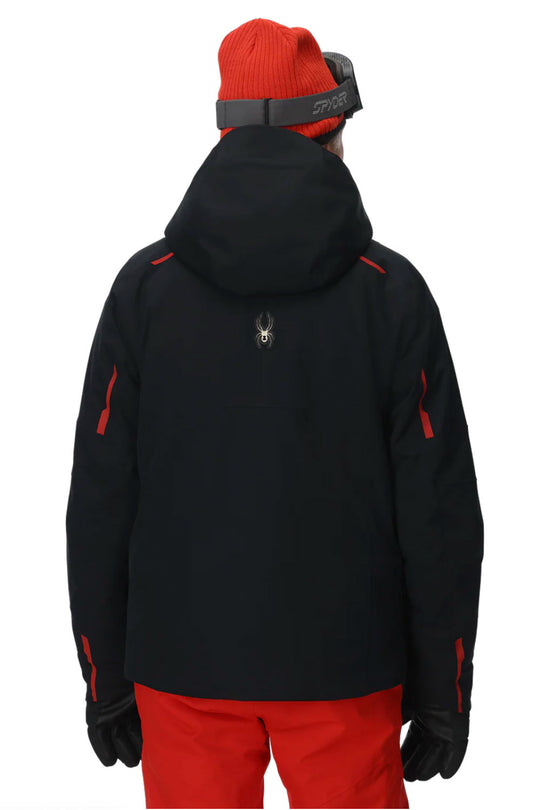 Person wearing a black jacket with red accents and red pants on a white background