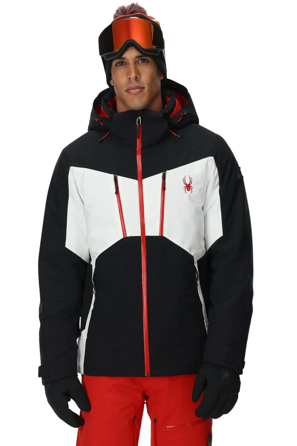 Person wearing a black, white, and red ski jacket with goggles on a white background