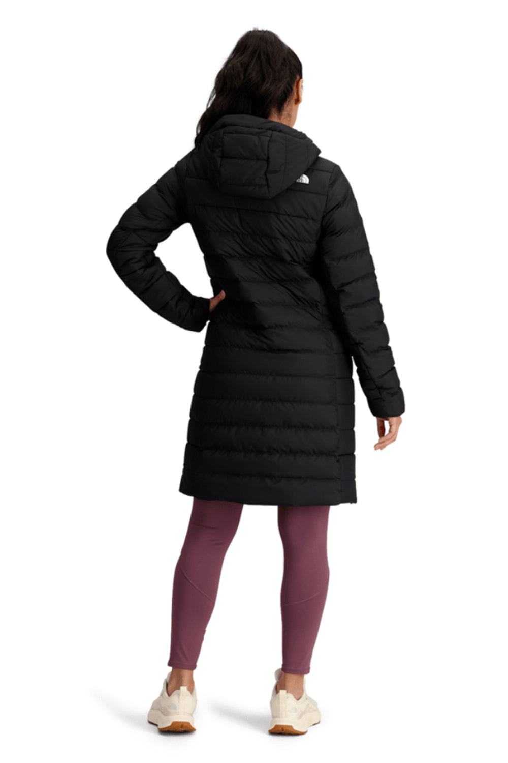 Person wearing a black winter coat with The North Face logo on a white background