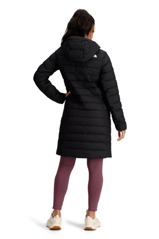 Person wearing a black winter coat with The North Face logo on a white background