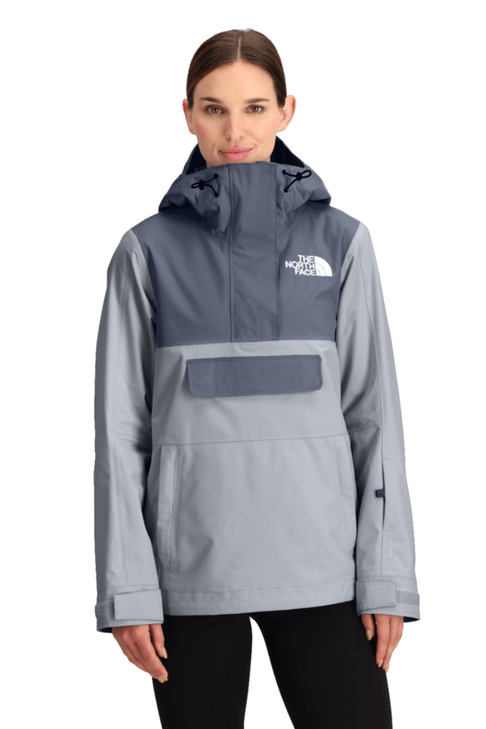 Woman wearing a gray and navy ski coat with The North Face logo on a white background