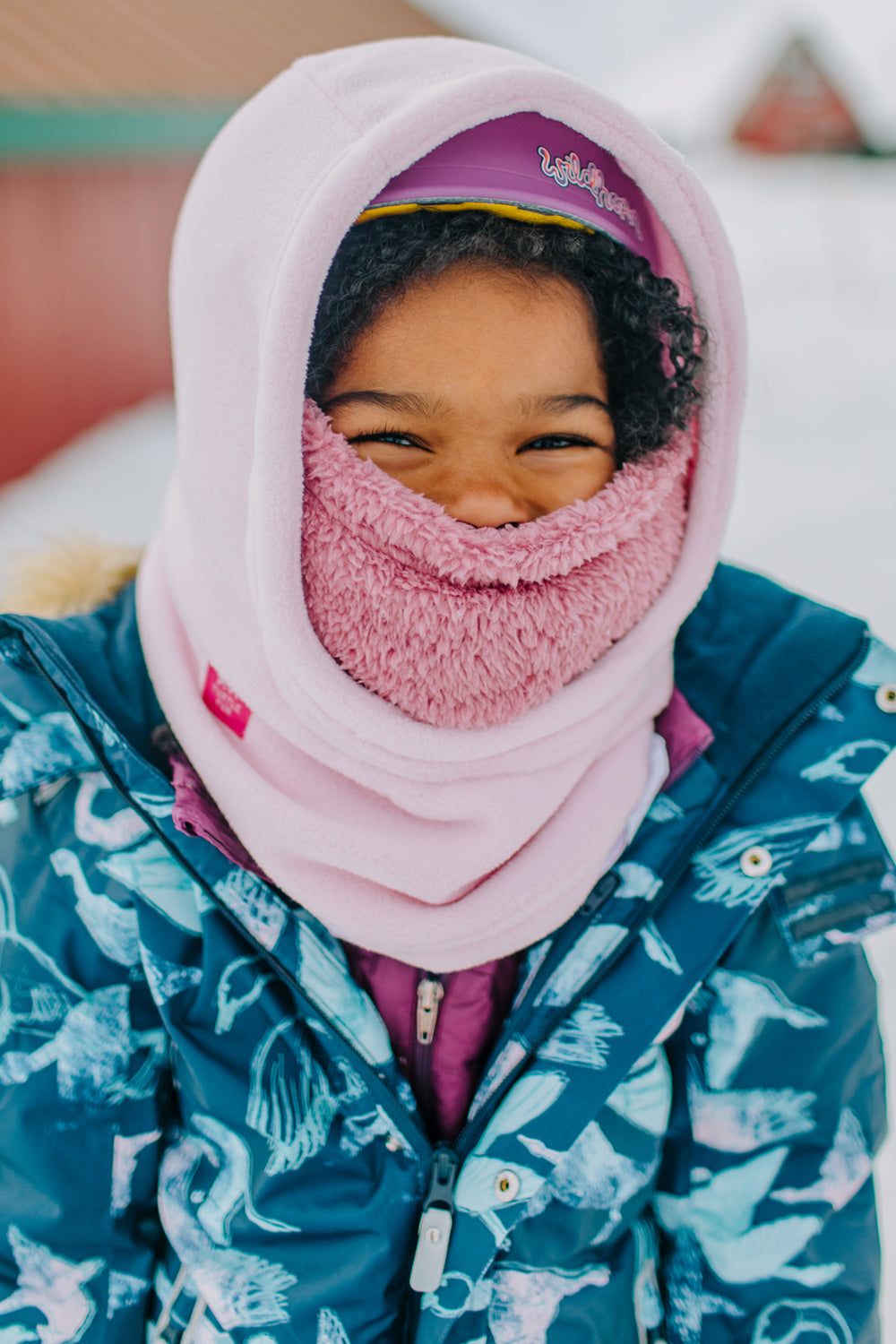 Person wearing a pink balaclava and blue patterned jacket