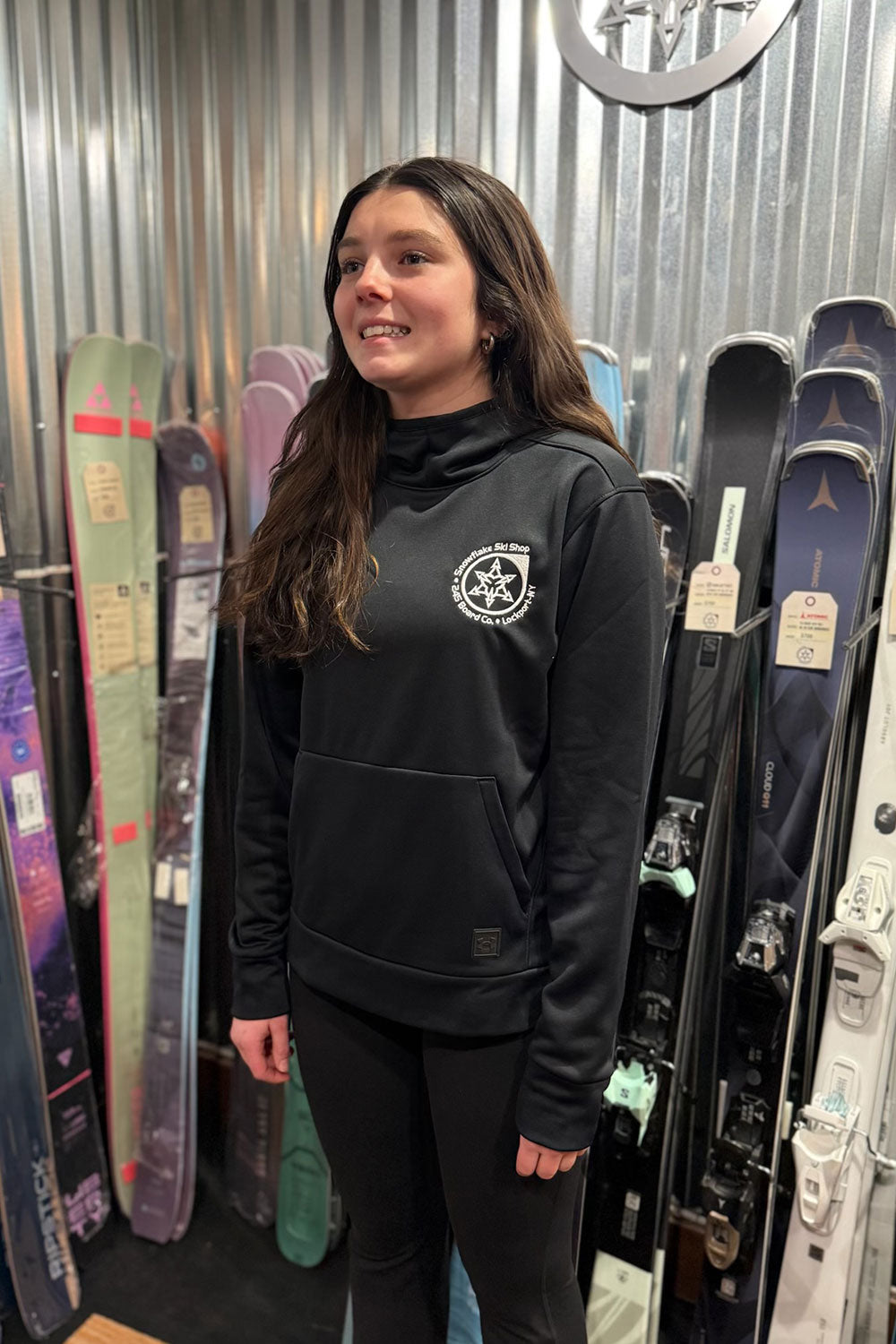 Woman standing in front of skis in a store