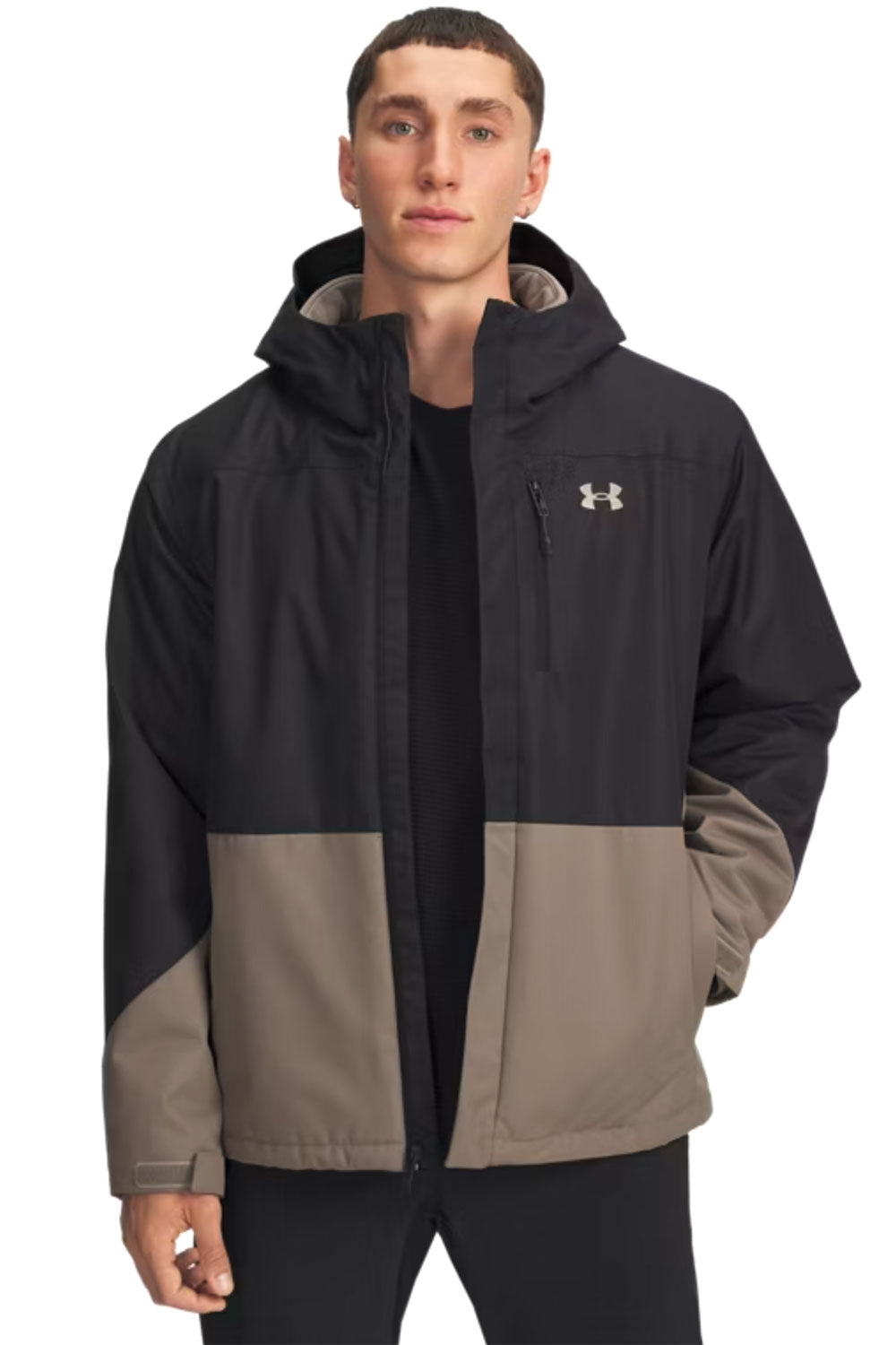 Man wearing a black and beige jacket with Under Armour logo on a white background