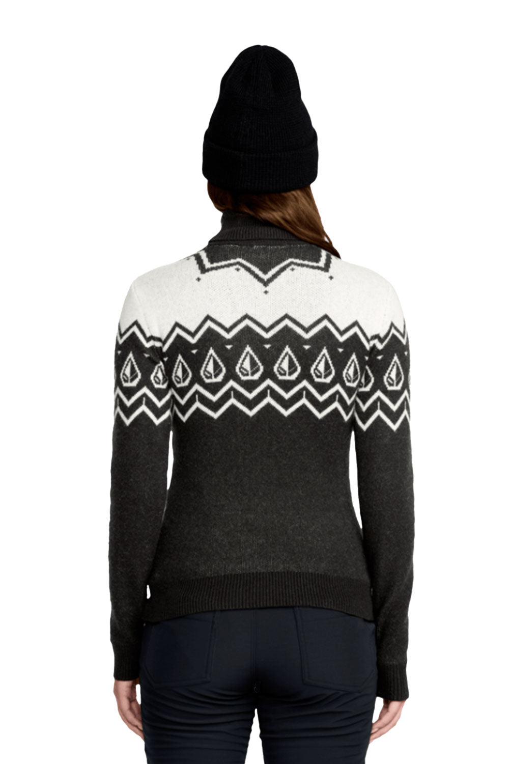 Person wearing a black and white patterned sweater with a black beanie on a white background